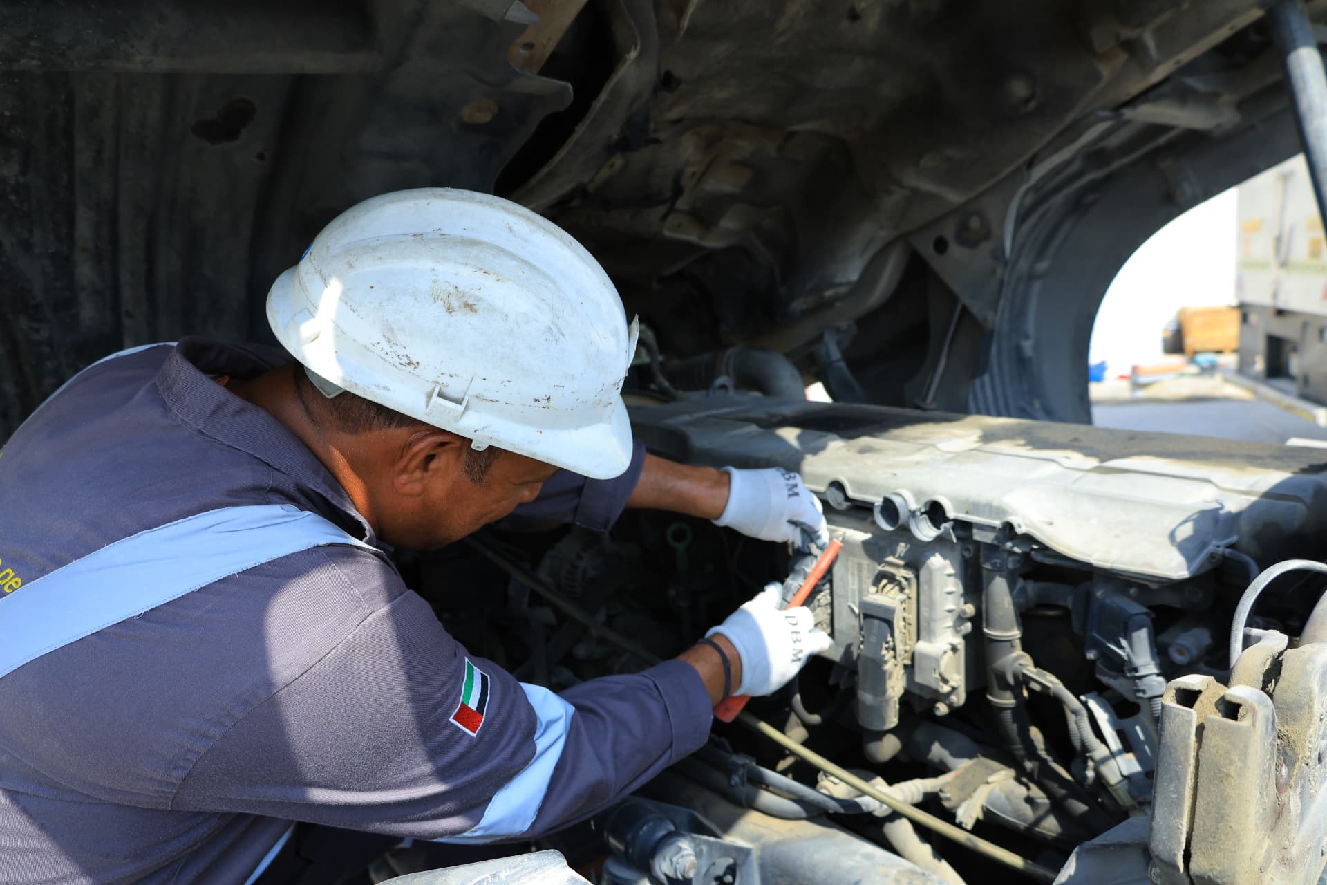 AutoDome mechanic repairing a truck engine with the cab tilted open